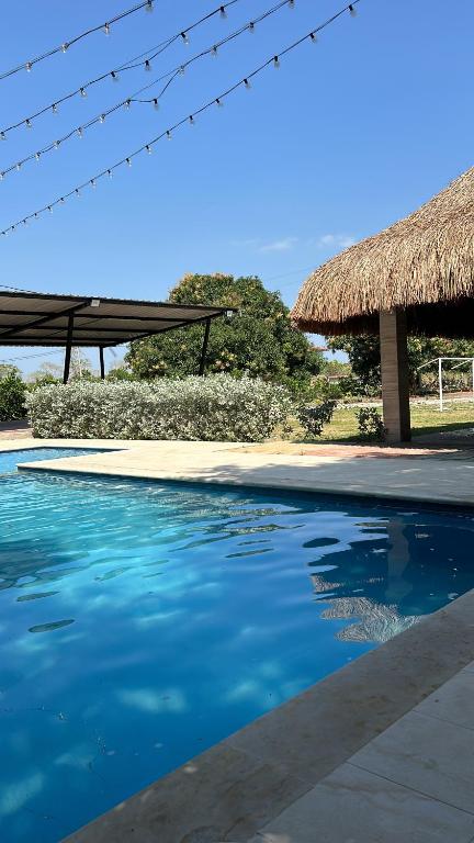 uma piscina de resort com telhado de palha em Hermosa cabaña la Promesa en Malambo. em Malambo