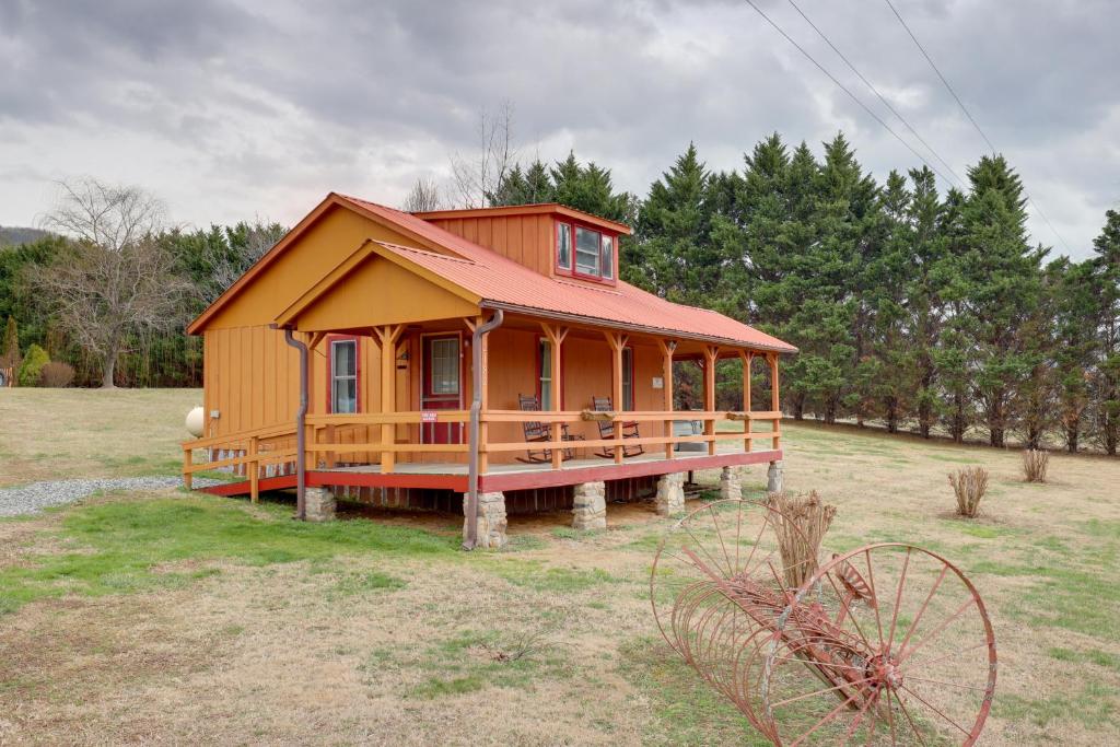 a small house with a red roof on a field at Blue Ridge Hideaway! Cabin w/ River Access & Views in Hot Springs