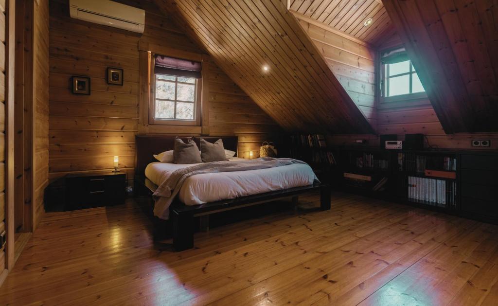 1 dormitorio con 1 cama en una cabaña de madera en Finland House Barcelona- Ideal familias, en Argentona