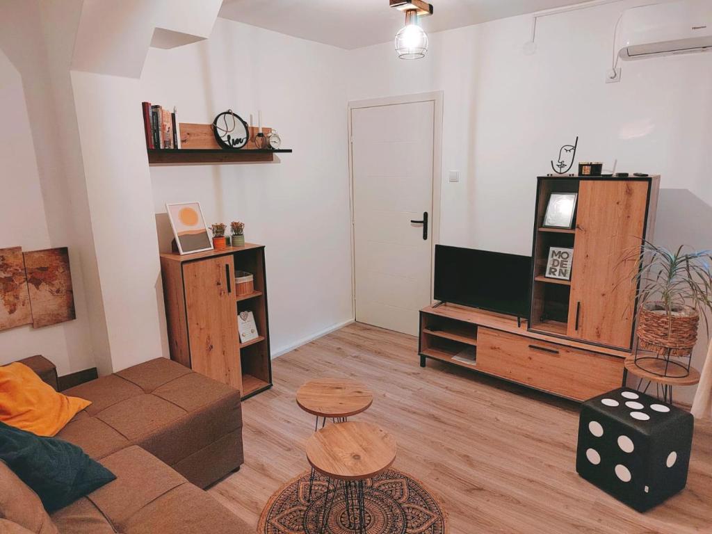 een woonkamer met een bank en een flatscreen-tv bij Oaza031 in Užice