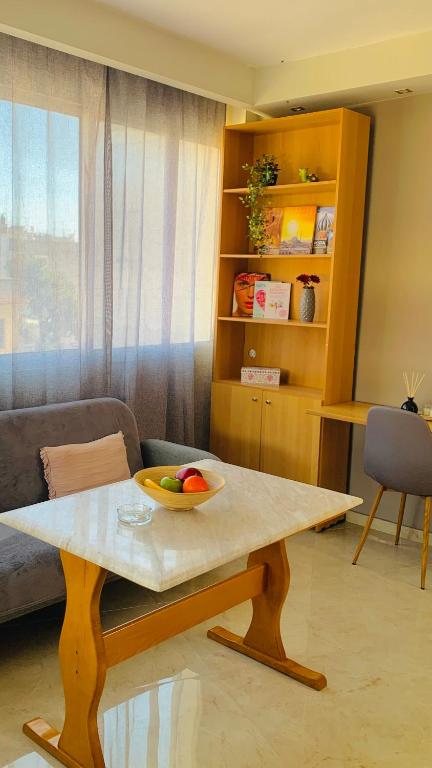 a living room with a table with a bowl of fruit on it at City view apartments 3’ in Serres