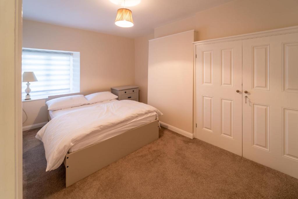 a bedroom with a bed and a window at Bumble Bee Cottage Witney Serviced accommodation in Witney