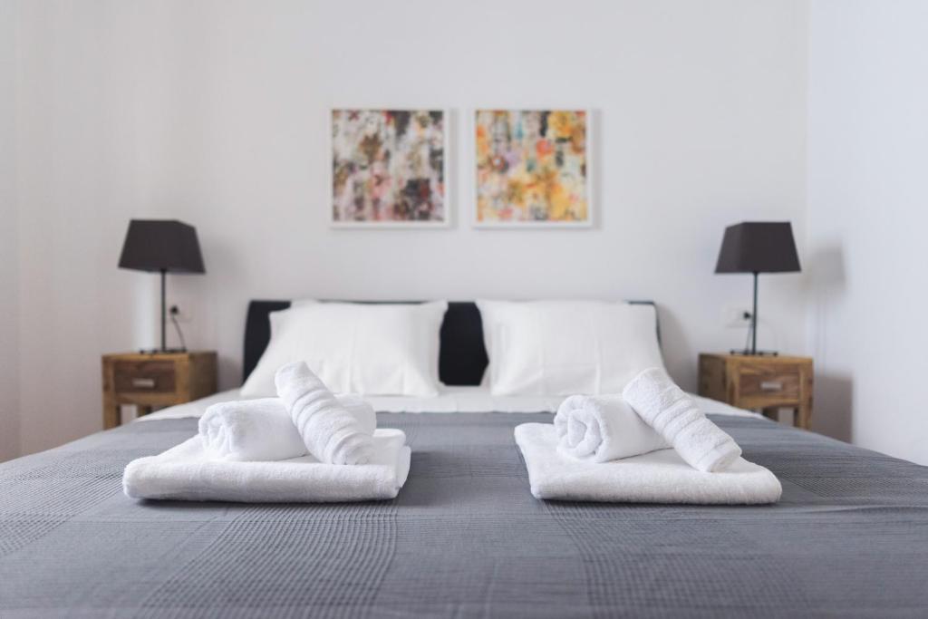 a bedroom with a bed with two white towels at M&A Apartments in Zadar