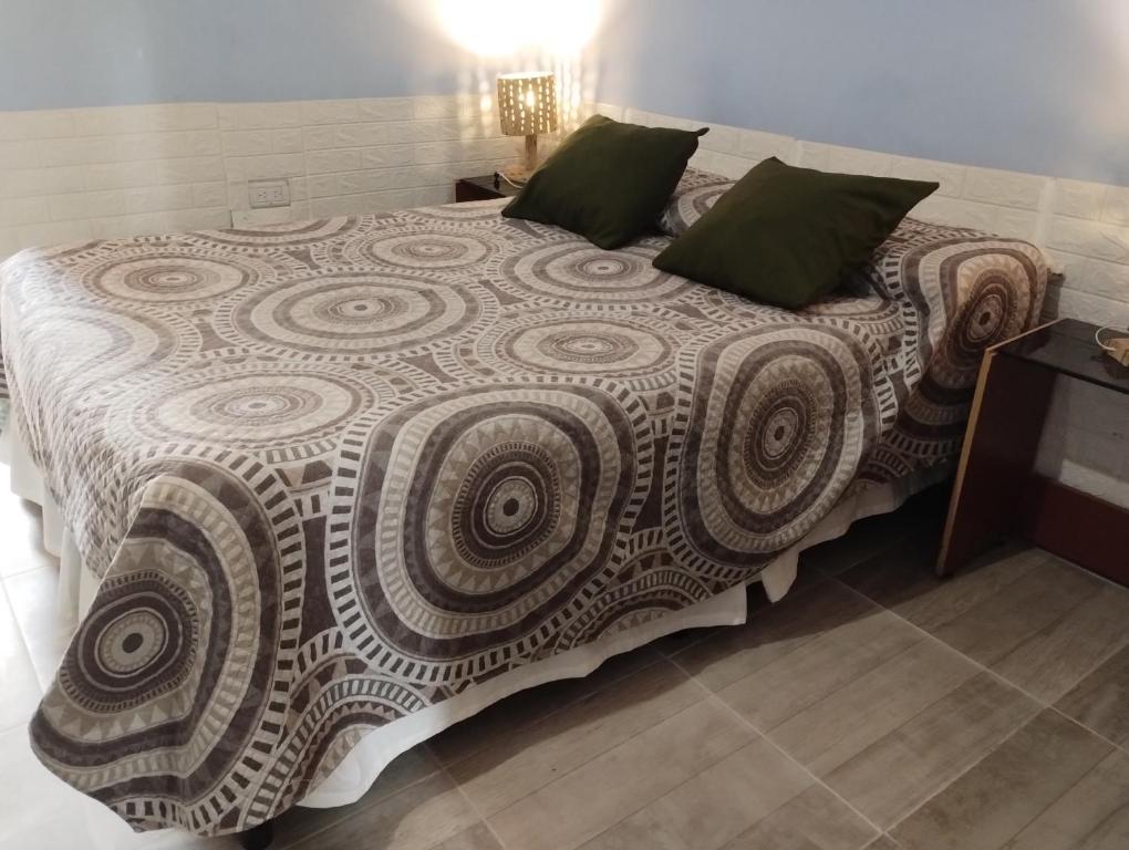 ein Schlafzimmer mit einem großen Bett mit grünen Kissen in der Unterkunft Casa del Arte in Salta