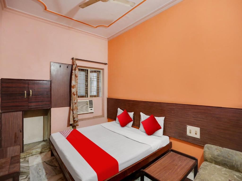 a bedroom with a bed with red pillows at OYO Flagship Jaiswal Star Stay in Lucknow