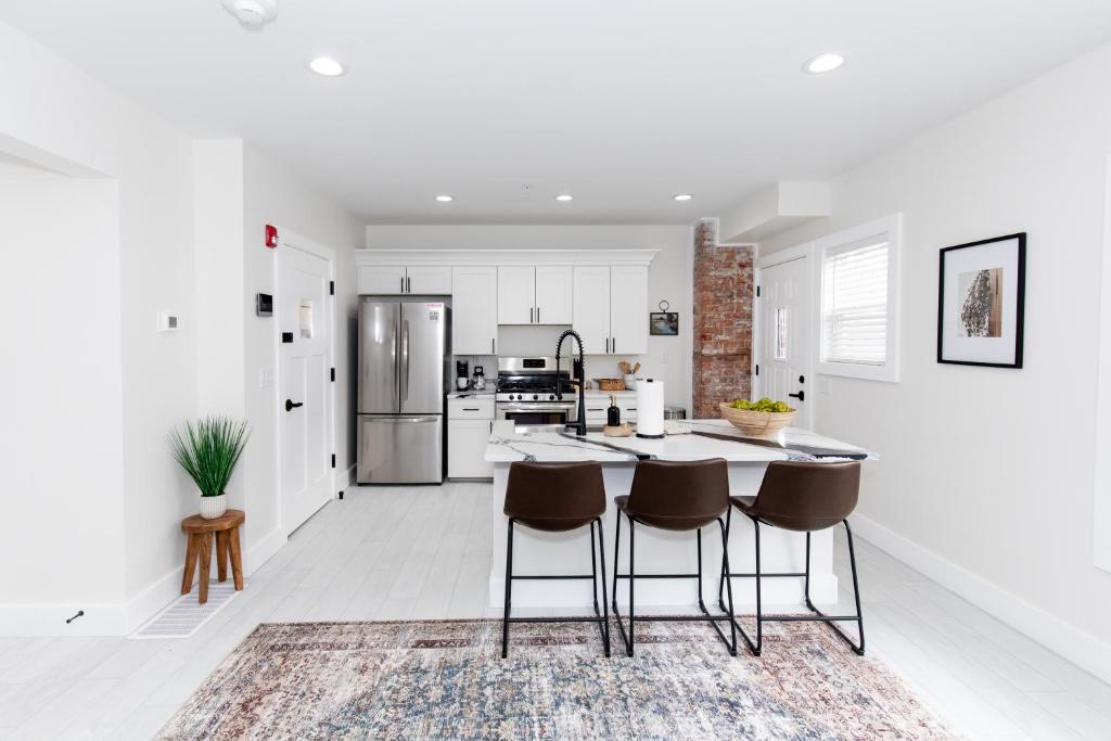 a kitchen with white walls and a table and chairs at The Inn at Fulton in Sandusky