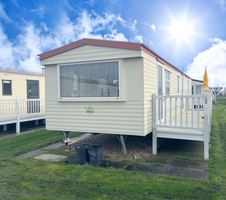 a tiny house is sitting in a yard at Golden Palm Resort - The Oasis - Coastal Caravan Breaks in Chapel Saint Leonards
