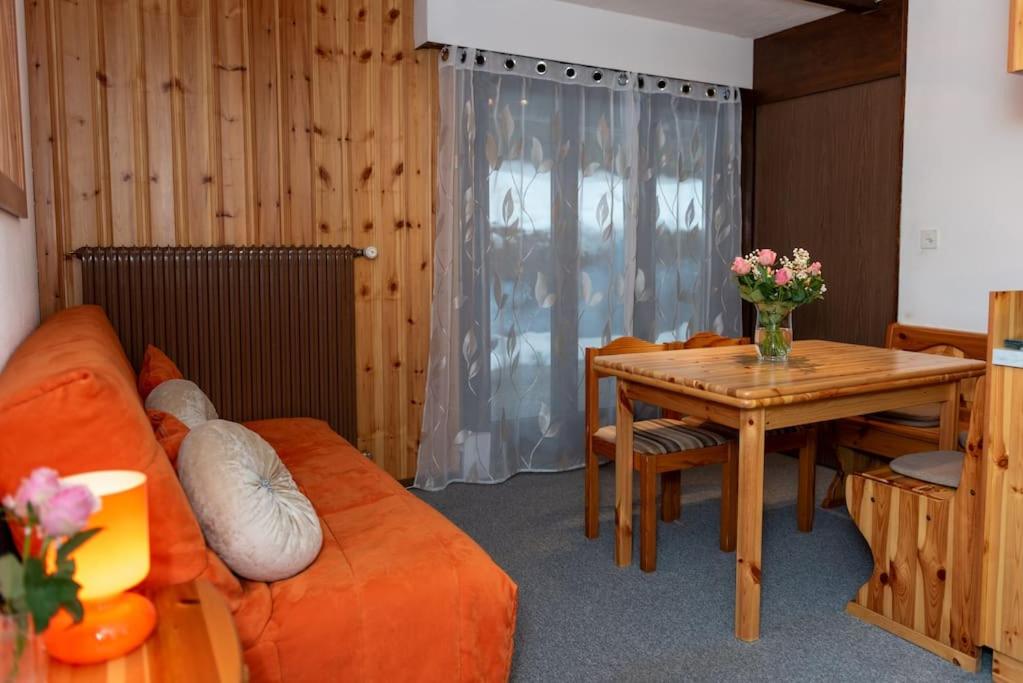 a living room with a couch and a wooden table at Chalet d'appartement avec une grande terrasse in Torgon