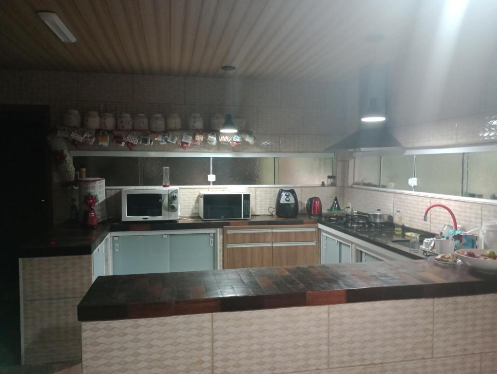 a large kitchen with a counter top and appliances at Pousada Maria Rosa in Blumenau