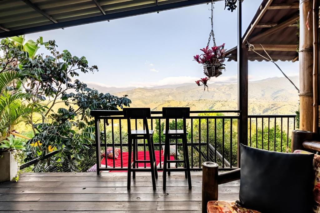 una mesa y sillas en una terraza con vistas a las montañas en Pachamama, en Salento