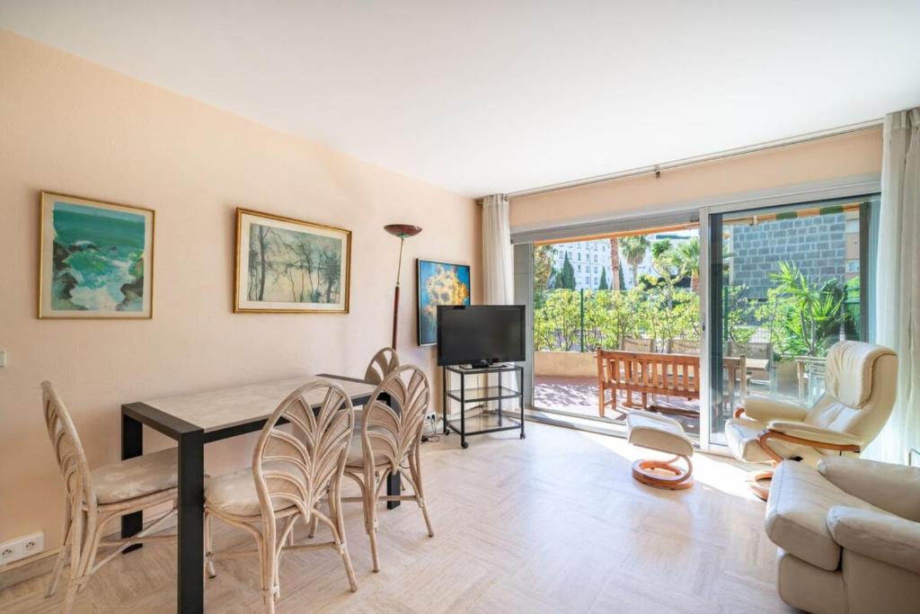 un salon avec une table et des chaises dans l'établissement Nice one bedroom on the garden level, à Cannes