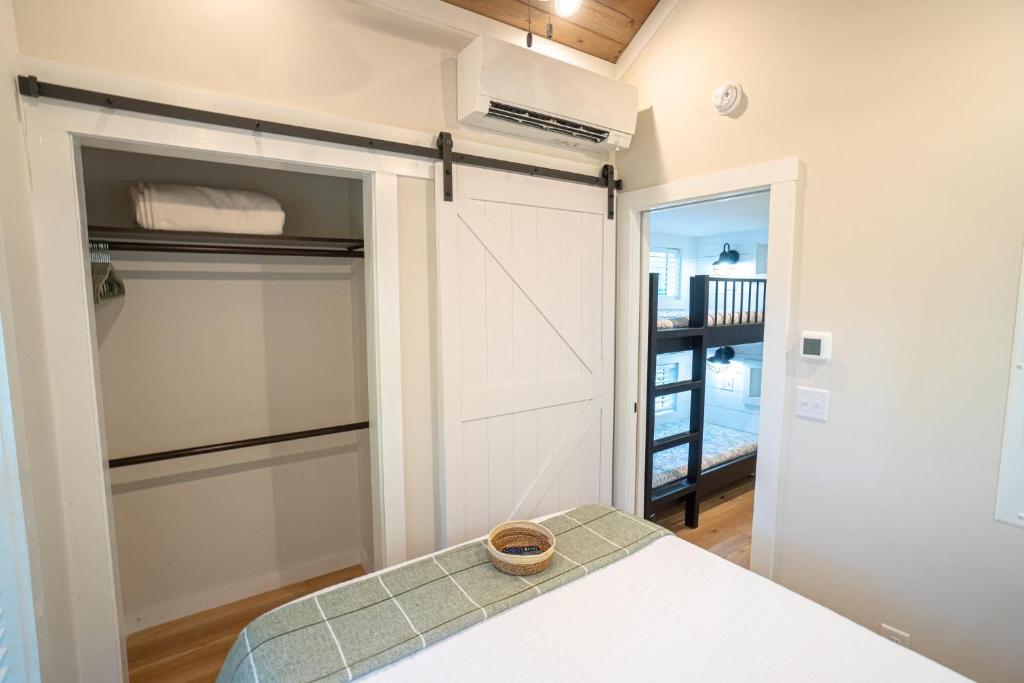 a bedroom with a closet with a door and a table at Farmhouse Tiny home with fishing Pond - Oak Cabin in Gatlinburg