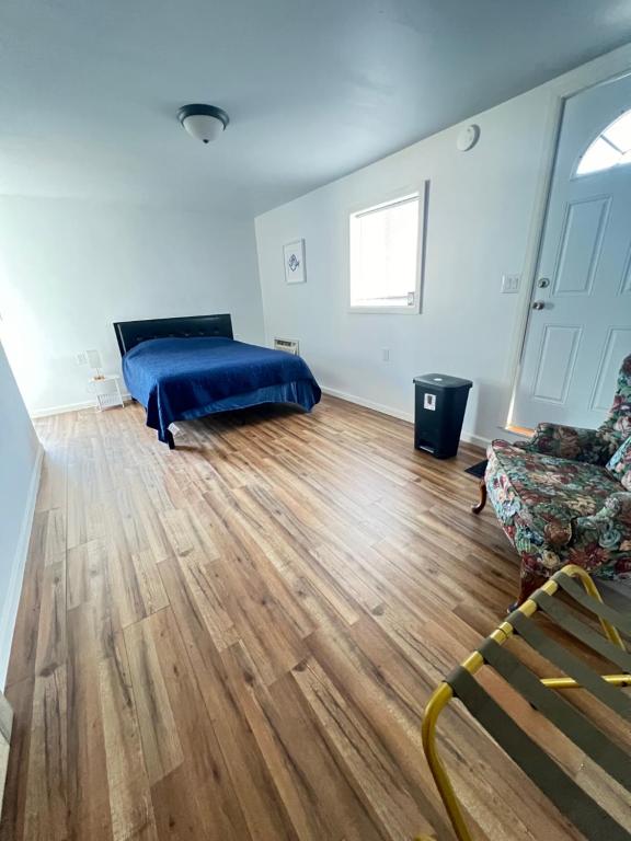 a bedroom with a bed and a couch and a wooden floor at LittleBettysCrashPad in Torrance
