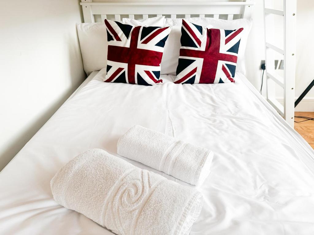 un letto bianco con asciugamani inglesi sopra di Drummond rooms a Londra