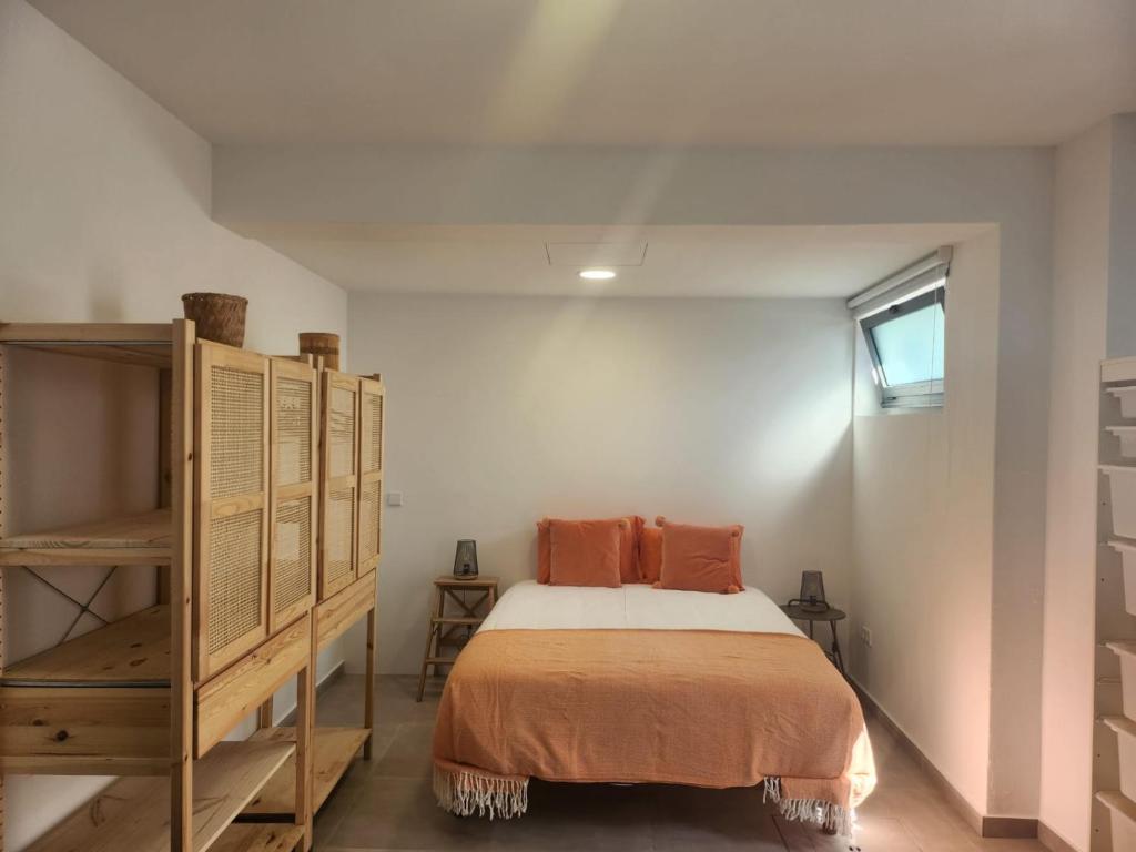 una camera da letto con un letto con cuscini arancioni sopra di Romantic Studio a Vila do Conde