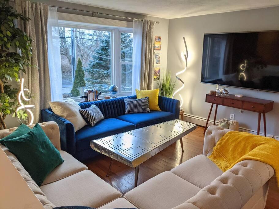 a living room with blue couches and a tv at #TheFlightdeck - Stylish Big Home Near Newport & Navy in Middletown