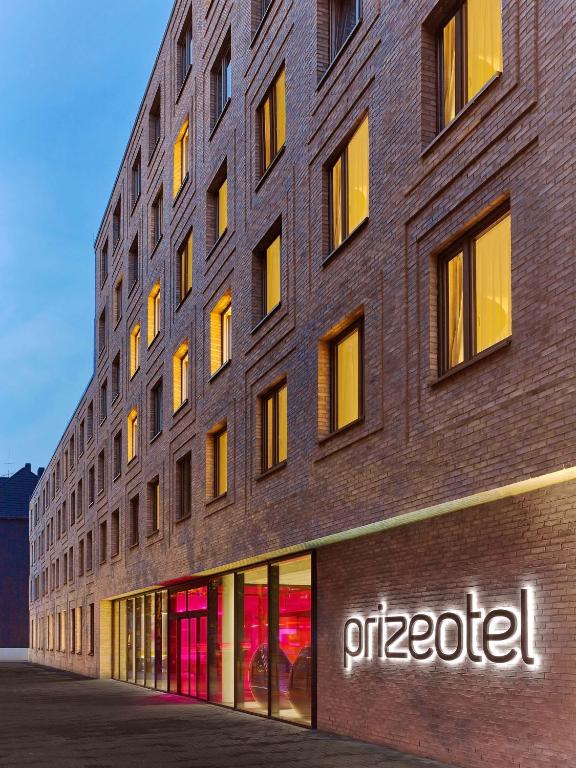 a tall brick building with a sign on it at prizeotel Hannover-City in Hannover
