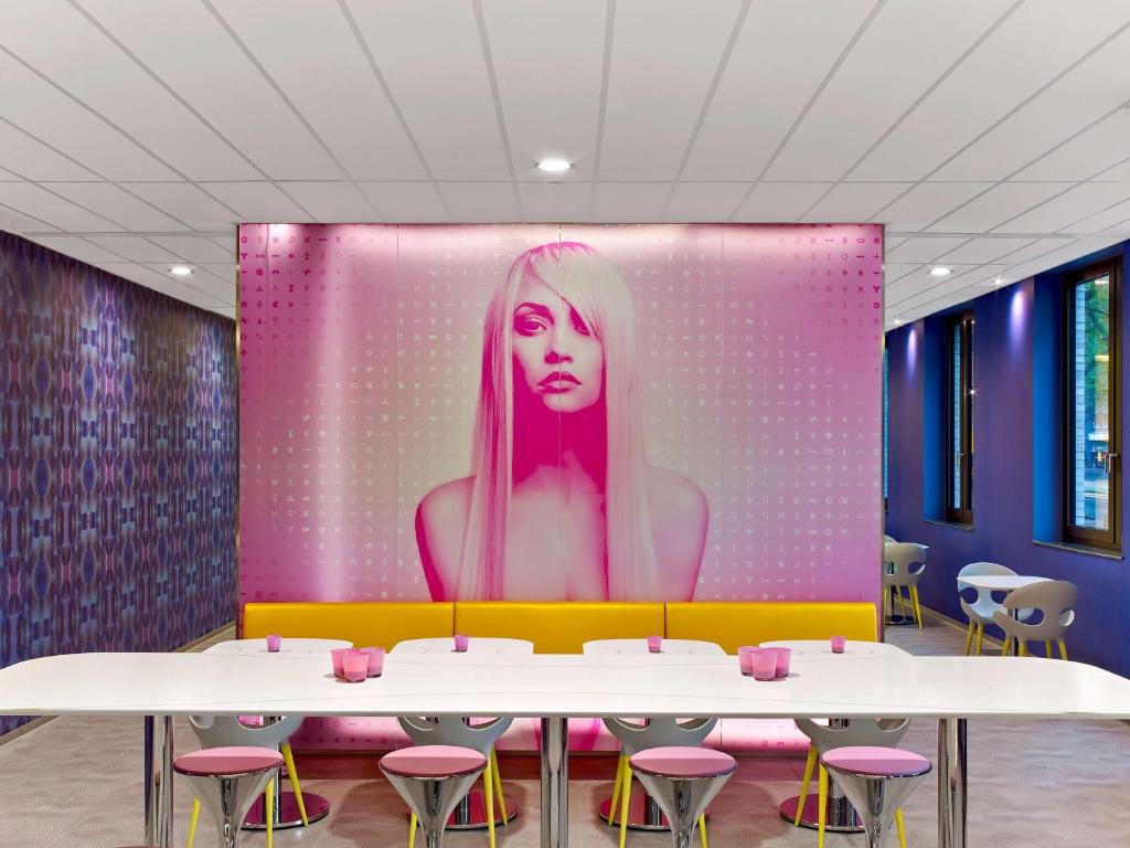a wall with a picture of a woman with pink hair at prizeotel Hannover-City in Hannover
