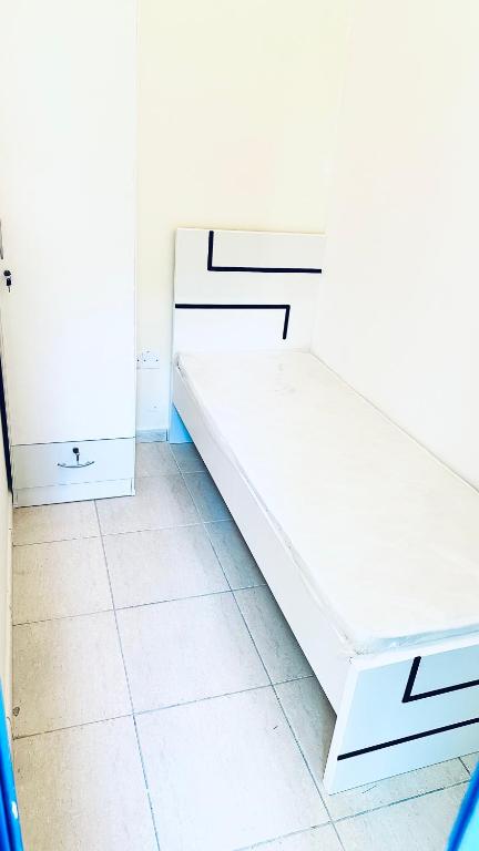 a white bedroom with white cabinets and a tiled floor at Khansaheb Residence in Dubai