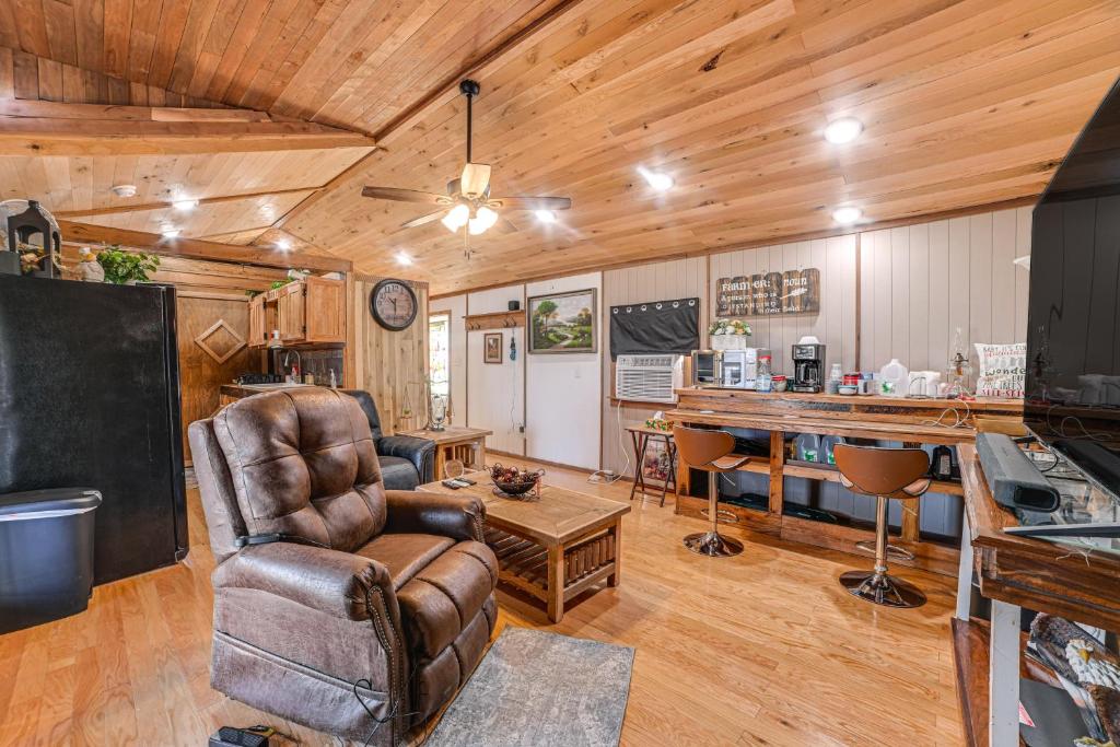 een woonkamer met een leren stoel en een tafel bij Kentucky Countryside Cabin Near Fort Campbell in Oak Grove