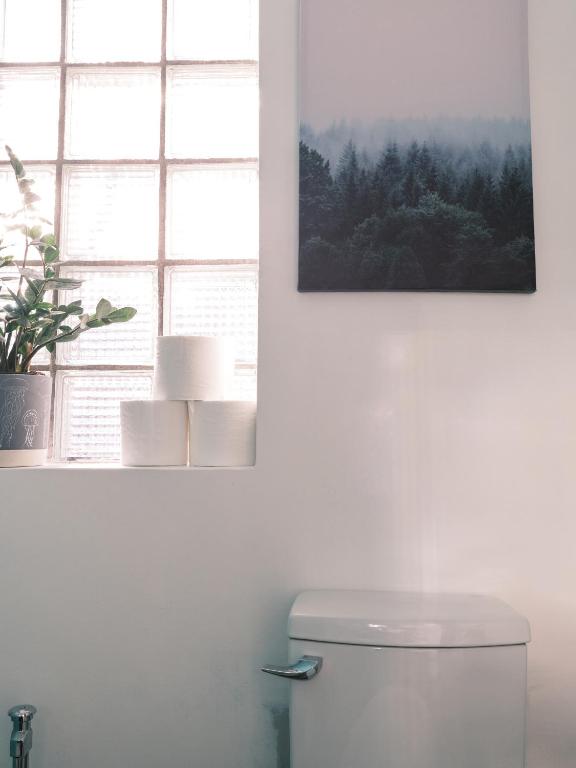 a bathroom with a toilet and a picture on the wall at BALCON BLANC - Auberge à Chicoutimi, Saguenay in Saguenay