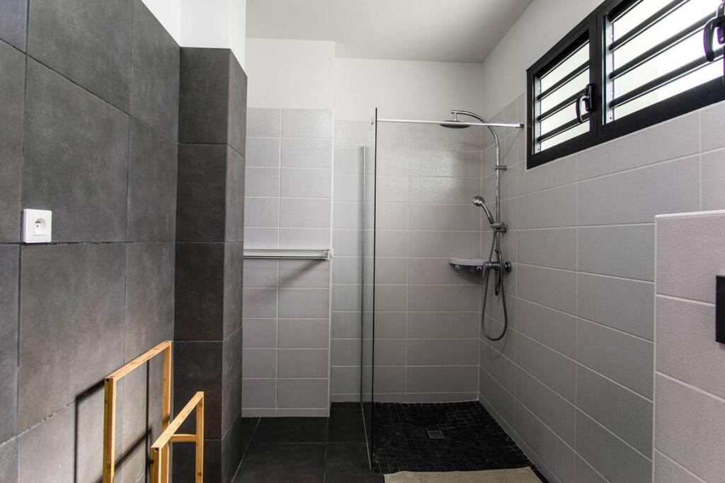 a bathroom with a shower with a glass door at Appartement Corail Bleu in Fort-de-France