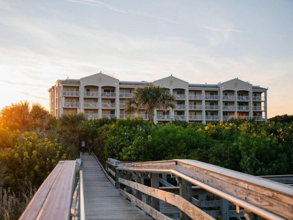 eine Promenade, die zu einem Resort mit einem Gebäude führt in der Unterkunft Holiday Inn Club Vacations Cape Canaveral Beach Resort in Cape Canaveral