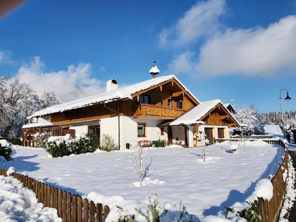ein Haus im Schnee mit einem Zaun in der Unterkunft Relax FeWo in Bayerisch Gmain