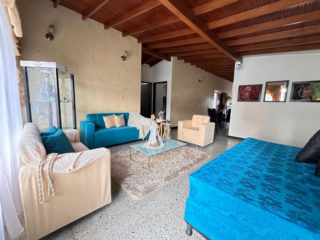 a living room with a blue couch and chairs at casa para 16 personas laureles in Medellín