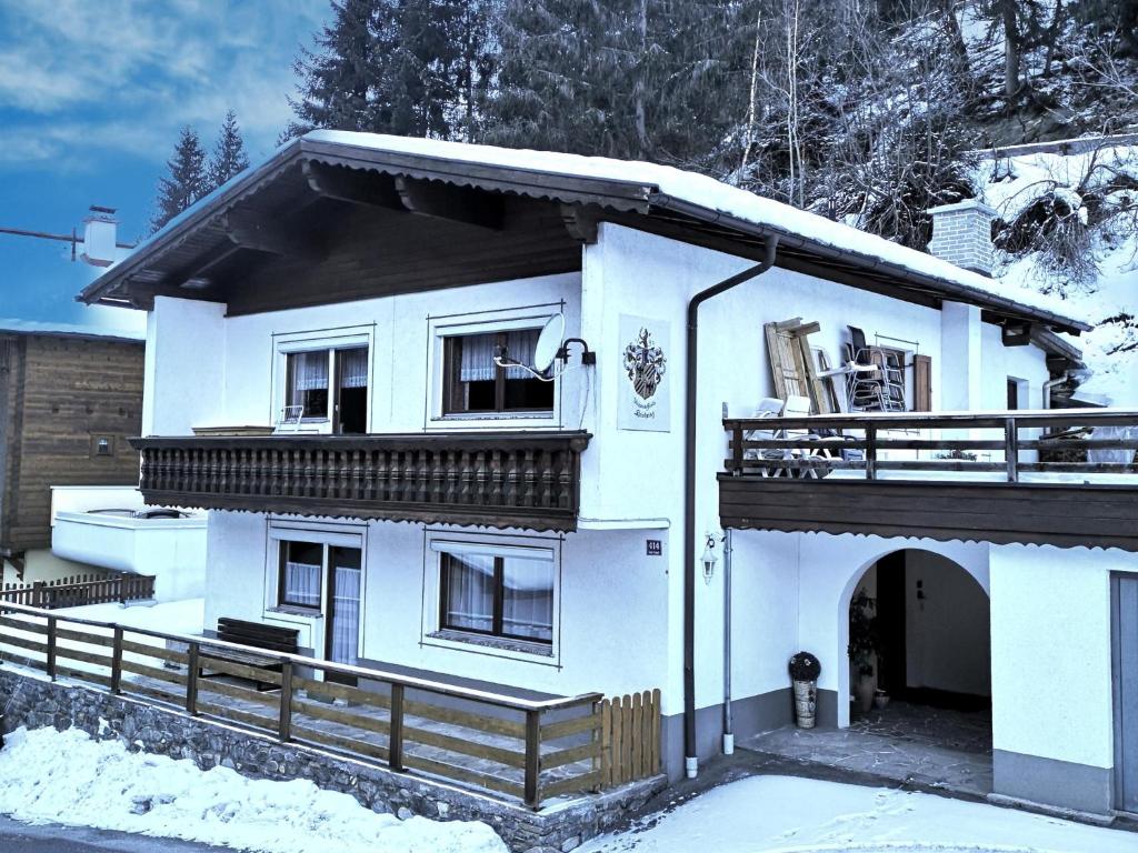 a white house with a balcony in the snow at Chalet Holdernach in Kappl