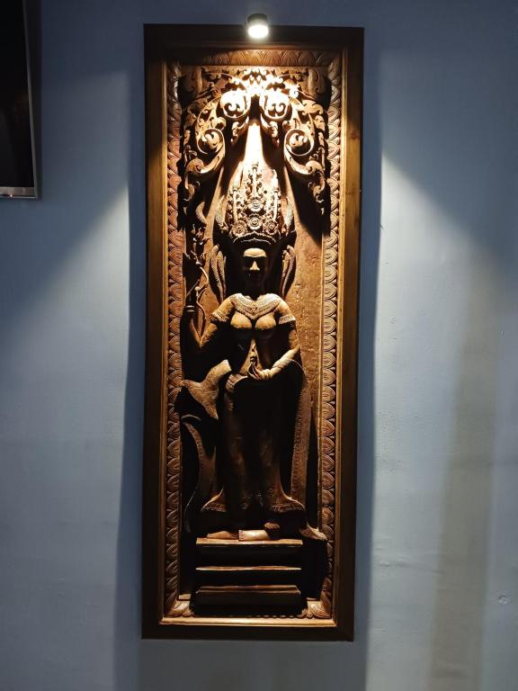 a wooden carving of a deity on a wall at Andy's Place in Siem Reap