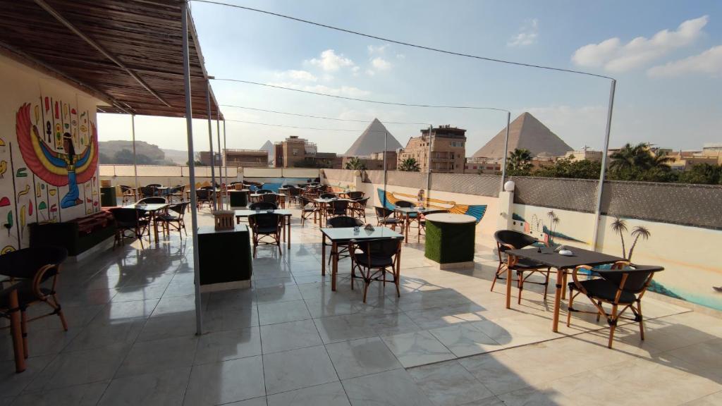 een dakterras met tafels en stoelen en piramides bij Nefertiti pyramids view in Caïro