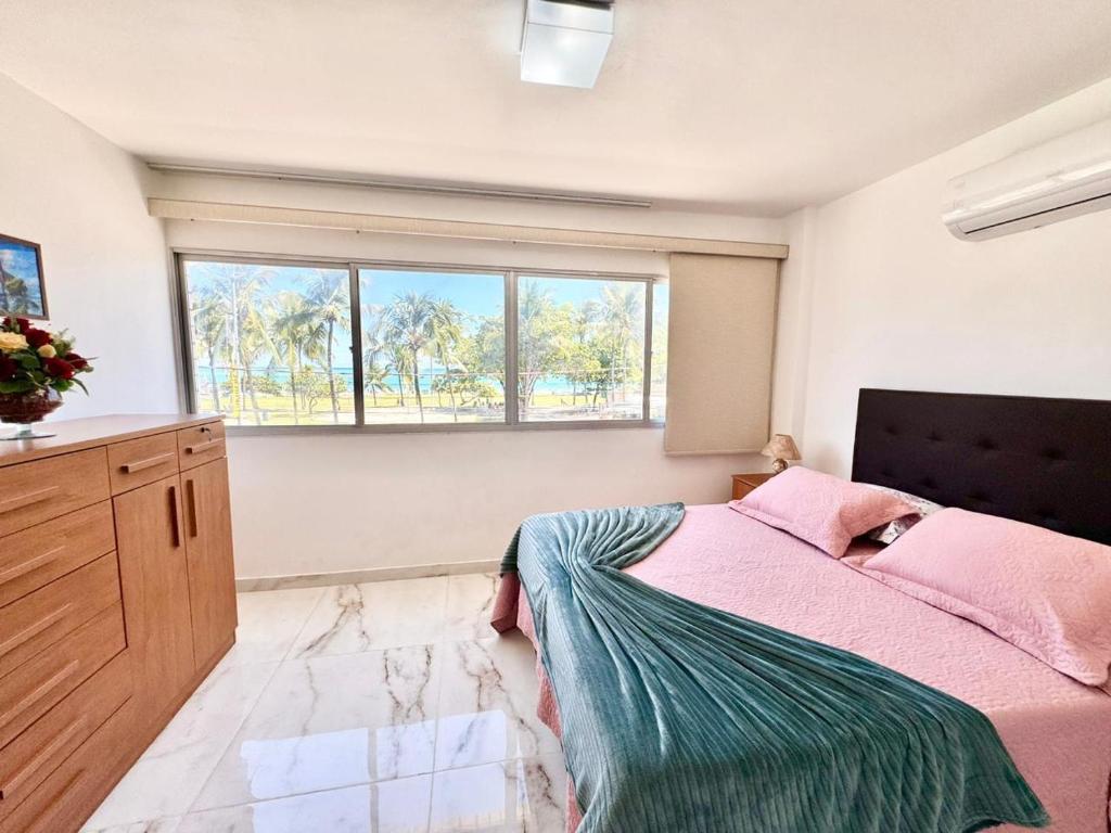 um quarto com uma cama e uma grande janela em Ed Canoa Apartamentos Temporada em Maceió