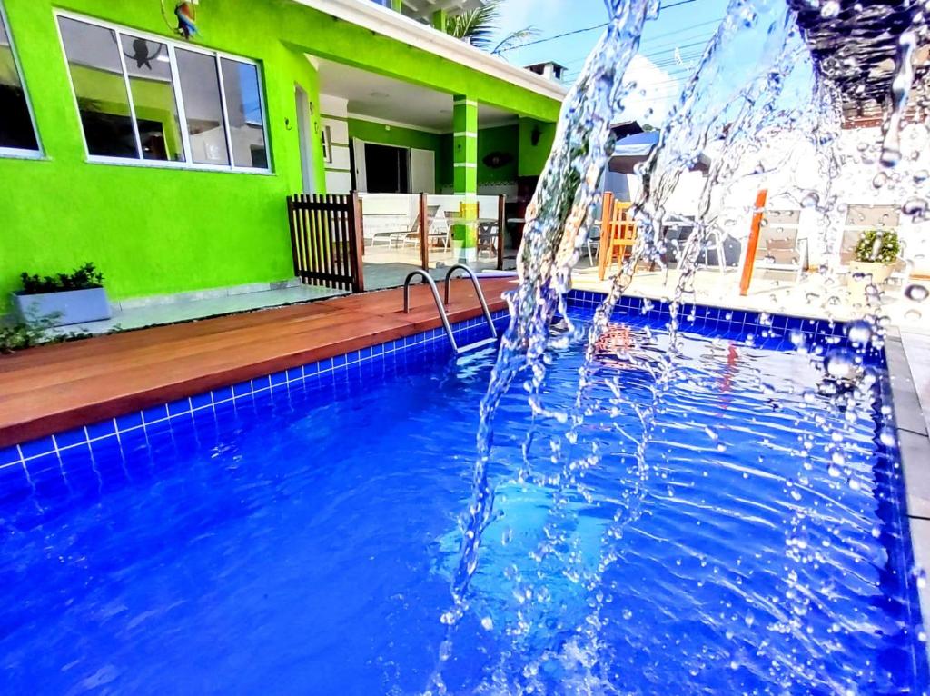 einen Pool mit einem Brunnen vor einem Haus in der Unterkunft casa com piscina in Ubatuba