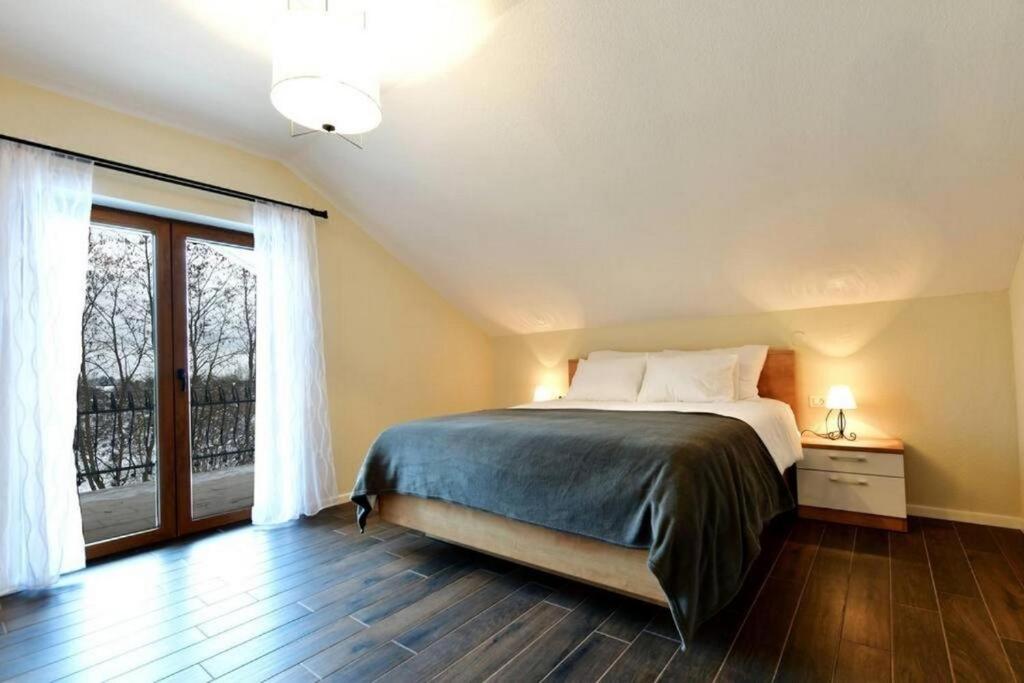 a bedroom with a bed and a large window at Secluded holiday house Dreznik Grad, Plitvice - 21288 in Rakovica