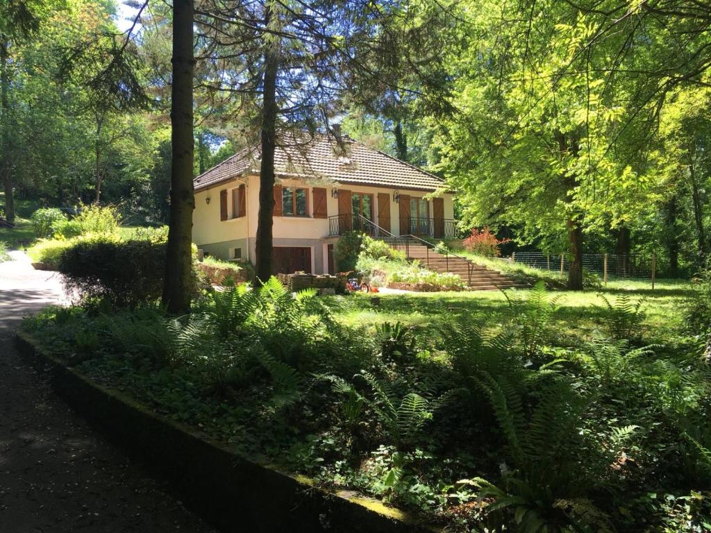 a house in the middle of a yard with trees at Belle Maison proche Disneyland in Montévrain