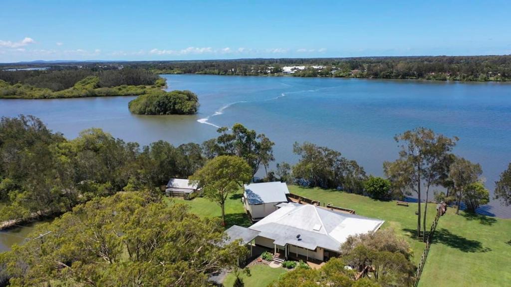 an aerial view of a house on a lake at Riverside Ranch - oceanstays in Yamba