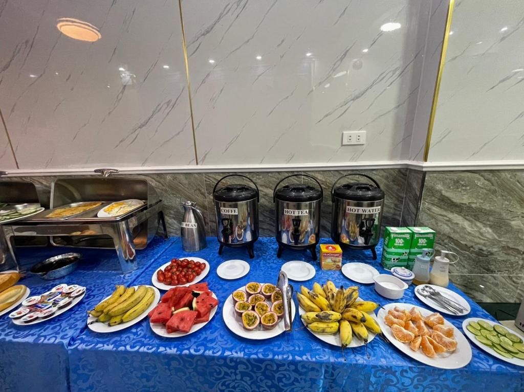 uma mesa azul coberta com pratos de alimentos e frutas em CHÂN TRỜI MỚI -NEW HORIZON HOTEL em Ilha de Cát Bà