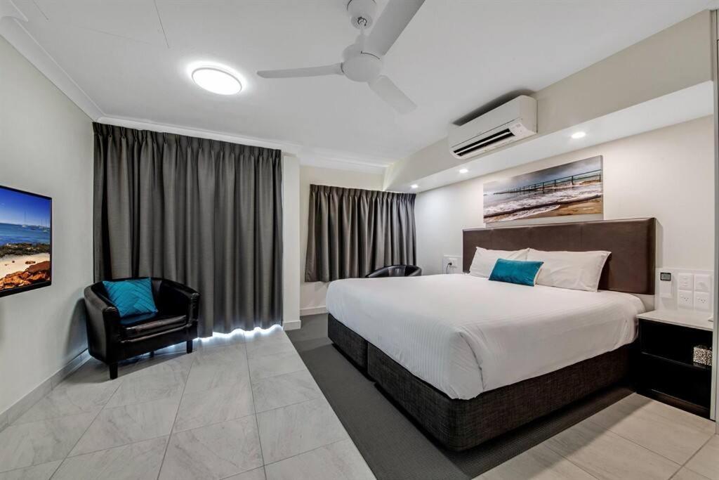 una habitación de hotel con una cama grande y una silla en Deluxe King Studio + top floor sea views, en Emu Park