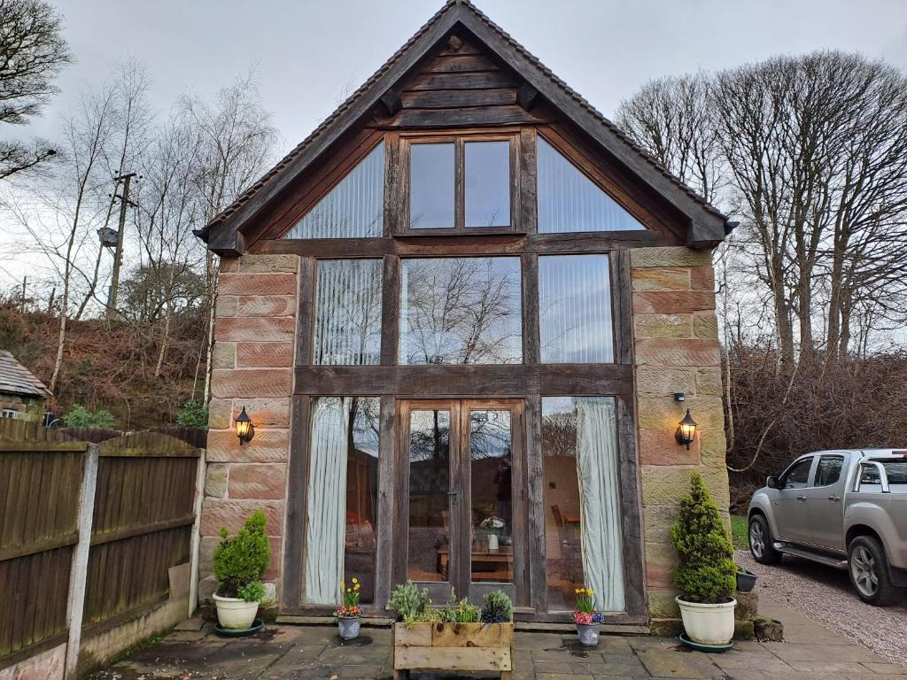 a tiny house with a large glass window at Orchard Cottage in Bradley in the Moors