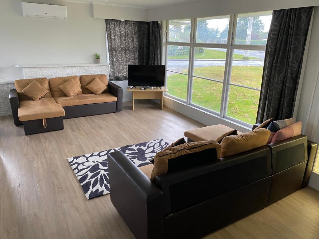Sala de estar con 2 sofás y TV en Your Home in Rotorua 3 Frank Street, en Rotorua