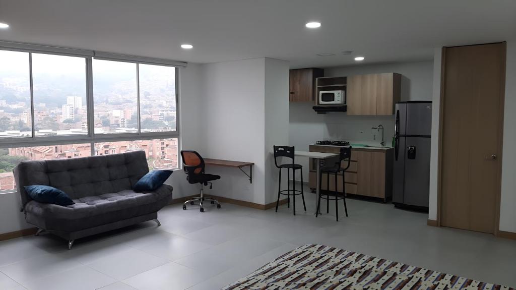 a living room with a couch and a kitchen at Confortable Aparta Loft 903 Aiana Verde in Medellín