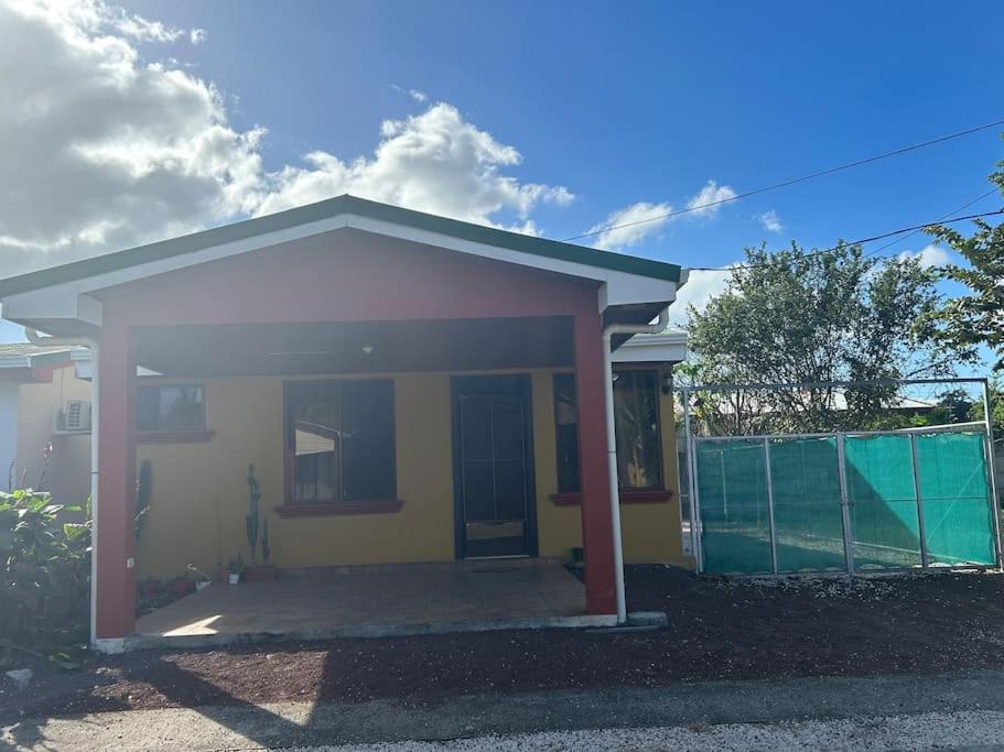 ein kleines gelbes und weißes Haus mit einem Zaun in der Unterkunft Casa Sendero in Liberia