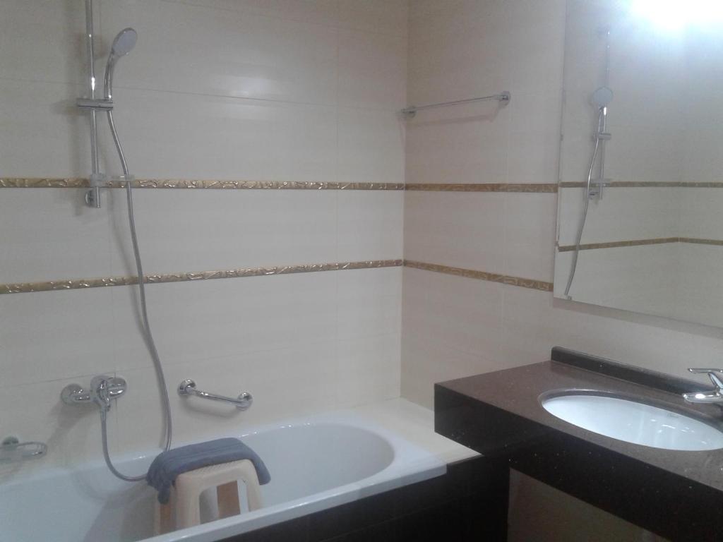 a bathroom with a sink and a bath tub at Grand Meteora Hotel in Kalabaka