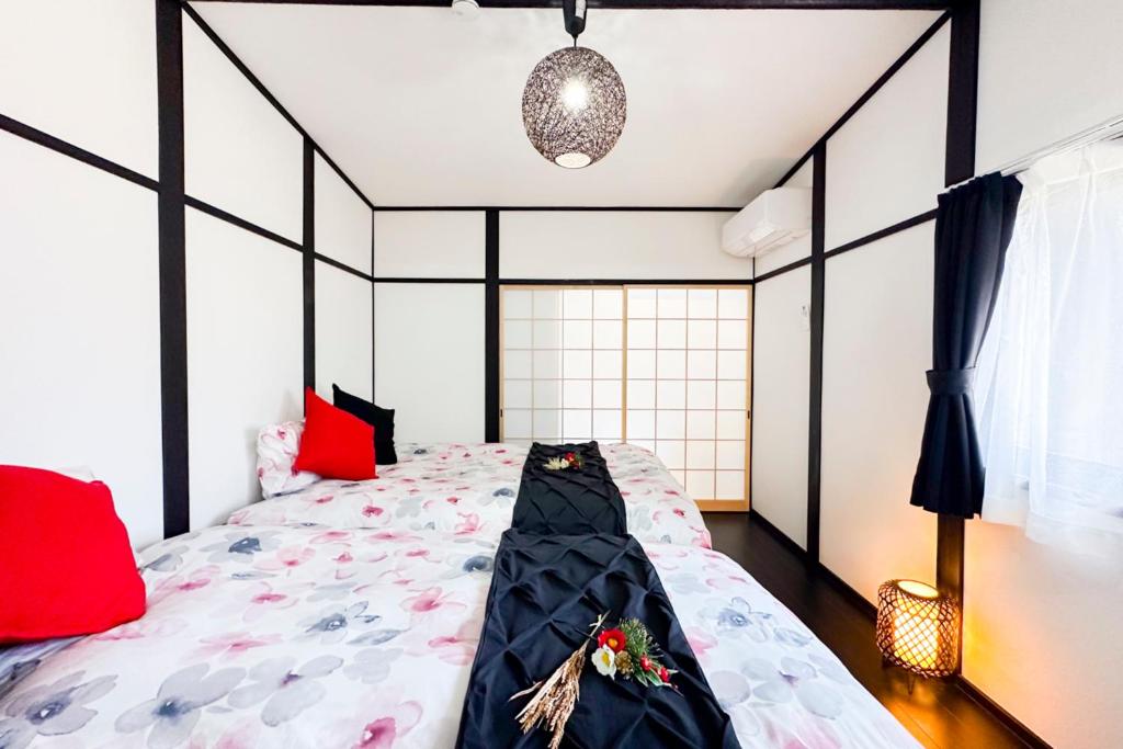 a bedroom with a black and white bed with flowers on it at OPEN SALE-Full renovation-stations 4 min-USJ& Namba nearby in Osaka