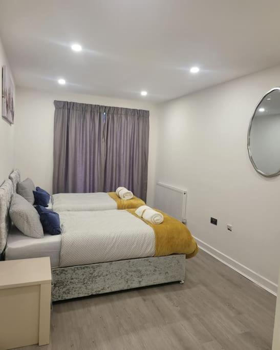 a bedroom with two beds and a mirror at 2 Bedrooms 2Baths 3Toilets near Excel City Airport O2 Sleeps up to 5 in London