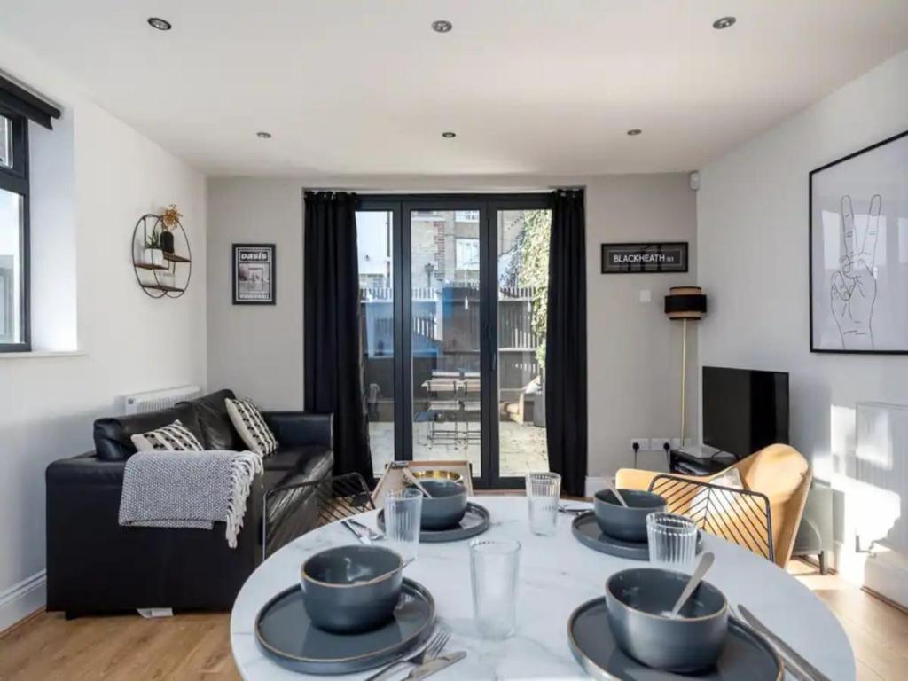 a living room with a table with dishes on it at Pass the Keys Modern and Bright Home Minutes From Central London in London