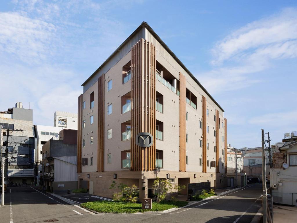 a building with a pointed roof on a street at Y-HOTEL in Hiroshima