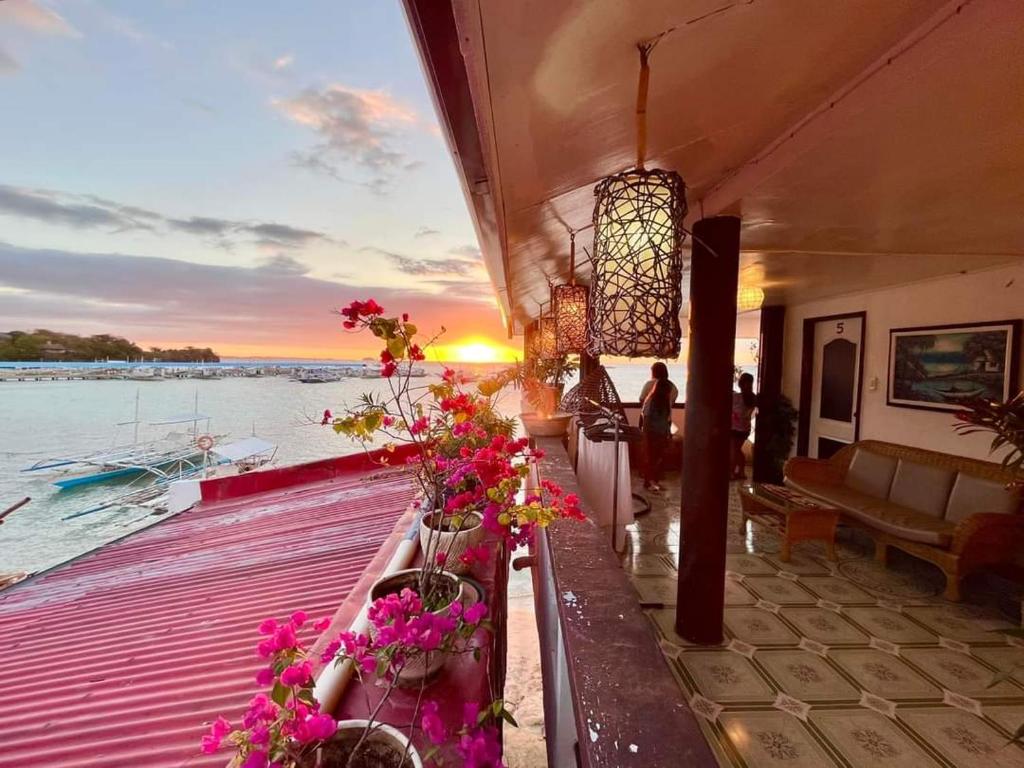 a group of flowers on a dock with the water at Seaside Hostel Malapascua in Malapascua Island