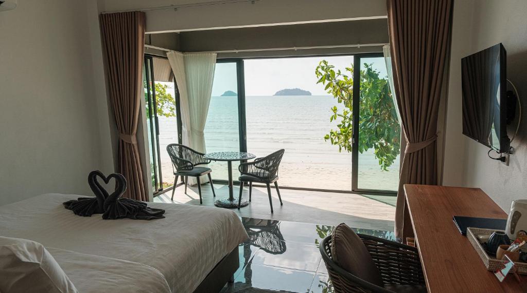 a bedroom with a bed and a view of the ocean at KaiBaeBeach GrandView in Trat